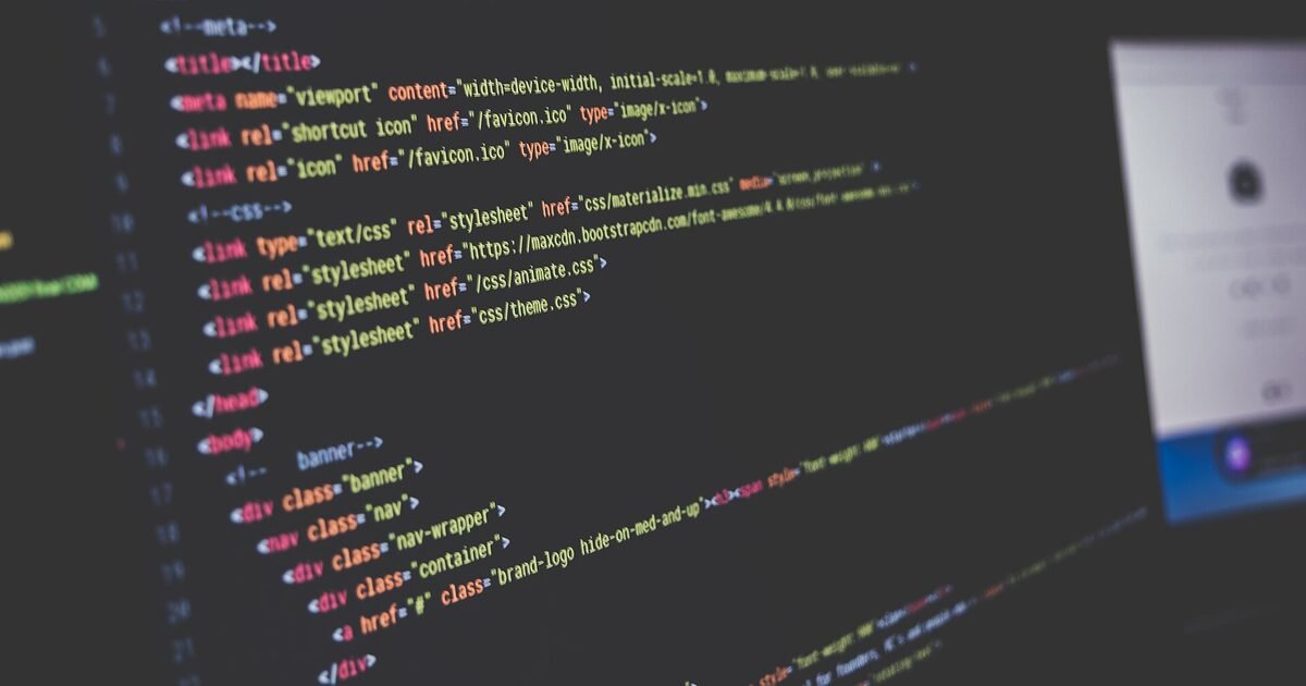 Close-up of a monitor displaying colour-highlighted HTML source code, including meta, title and stylesheet tags