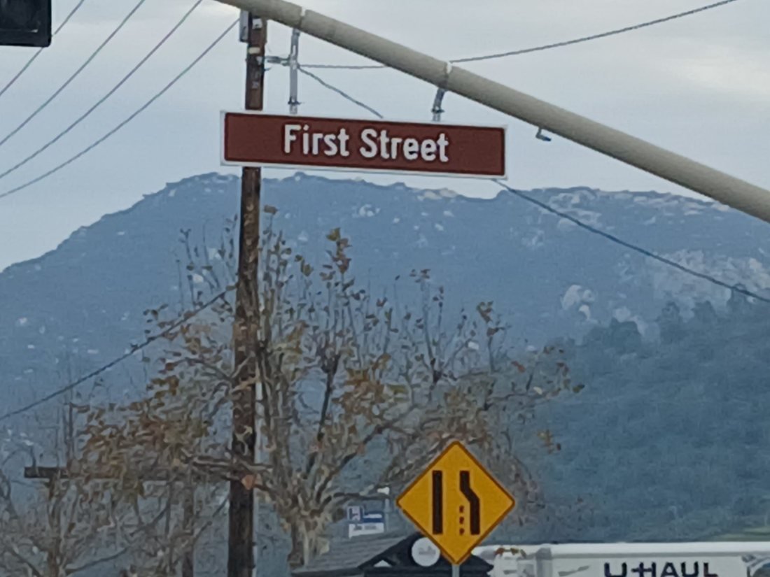 The First Street sign in Old Town Temecula with the hills behind it