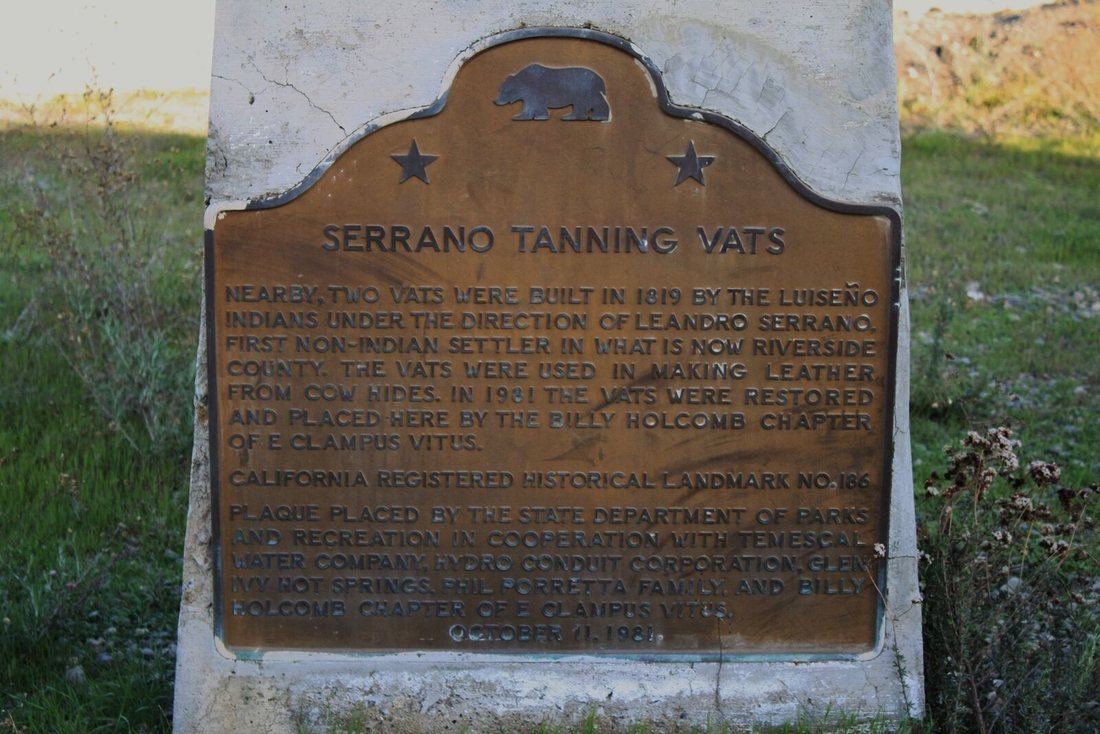 A weathered historical marker plaque for the Serrano Tanning Vats in Corona